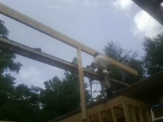 Carpenter setting a ridge beam over a new addition frame — Ice Dam Removal by Roofing Brothers in Streamwood