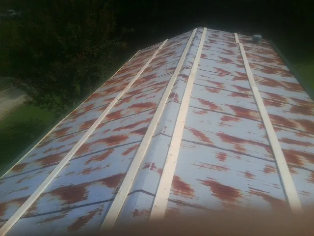 Rusted metal roof panels with new wood purlins before replacement — Storm Damage Roof Repair in Streamwood by Roofing Brothers