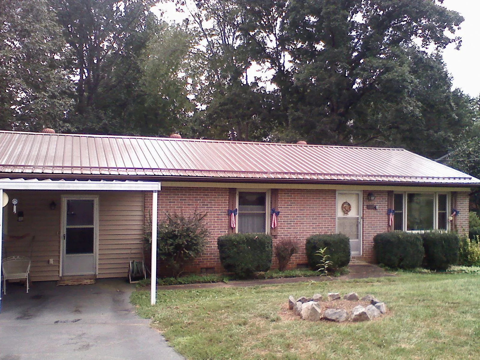 Bronze metal roof and carport on a brick ranch home — Roof Repair work by our crew in Streamwood